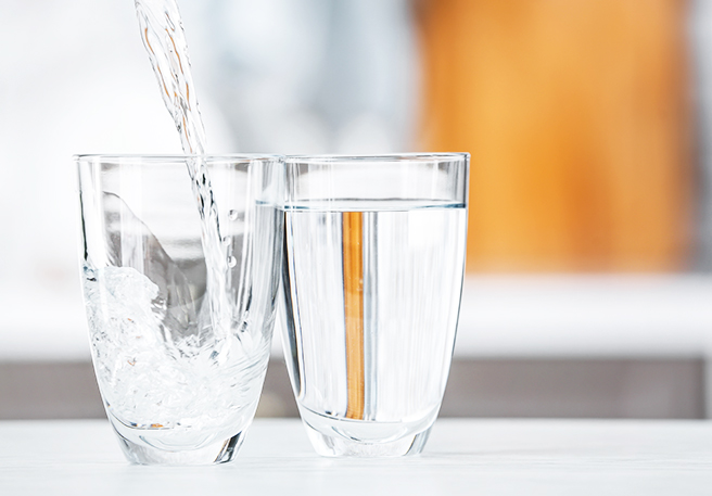 Wasserglas wird eingeschenkt