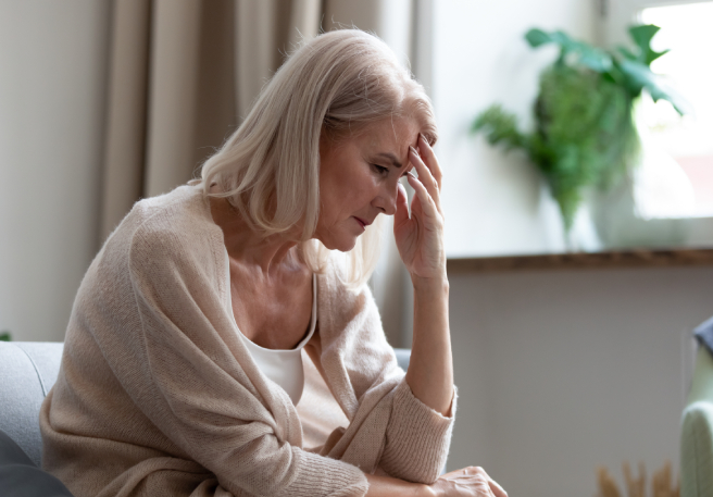Frau fasst sich an die Stirn | Migräneattacke